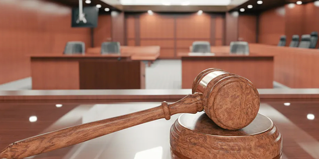 Inside a courtroom with gavel in view. 