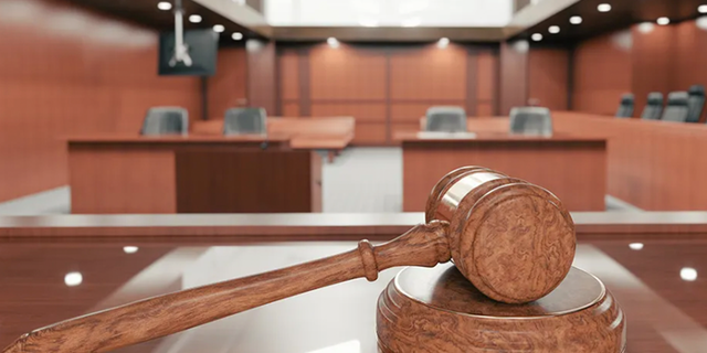 Inside a courtroom with gavel in plain view. 