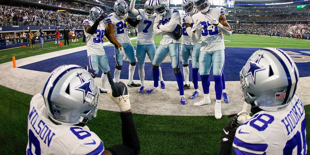 La defensa de los Dallas Cowboys celebra después de una intercepción durante la primera mitad de un partido de fútbol americano de la NFL contra los Philadelphia Eagles el sábado 24 de diciembre de 2022 en Arlington, Texas.