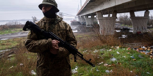 A Ukrainian serviceman patrols the area near the Antonovsky Bridge which was destroyed by Russian forces after their withdrawal from Kherson, Ukraine.  The Biden administration announced an additional $275 million in military aid to Ukraine on Friday. 