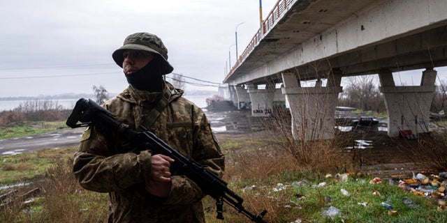 A Ukrainian serviceman patrols area near the Antonovsky Bridge which was destroyed by Russian forces after withdrawing from Kherson, Ukraine. The Biden administration announced Friday another $275 million in military aid to Ukraine. 