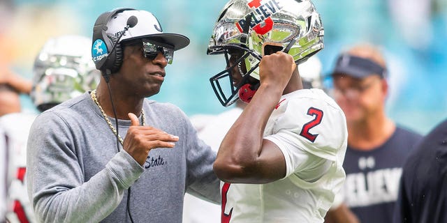 Jackson State Tigers head coach Deion Sanders speaks with quarterback Shedeur Sanders during the Orange Blossom Classic against the Florida A&M Rattlers on Sept.  5, 2021, at Hard Rock Stadium in Miami Gardens.