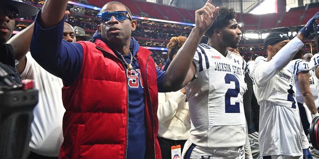 Head coach Deion Sanders and Shedeur Sanders (2) of the Jackson State Tigers after the end of the second half of the Celebration Bowl at Mercedes-Benz Stadium Dec. 17, 2022, in Atlanta.
