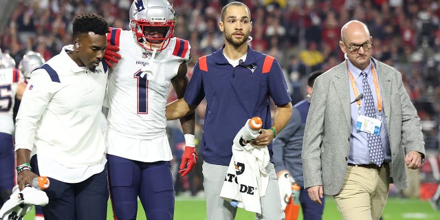 DeVante Parker (1) of the New England Patriots is helped off the field after a play against the Arizona Cardinals during the first quarter of a game at State Farm Stadium Dec. 12, 2022, in Glendale, Ariz.