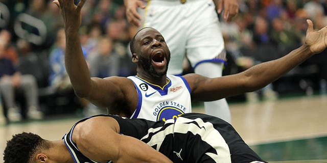 Giannis Antetokounmpo #34 of the Milwaukee Bucks is fouled by Draymond Green #23 of the Golden State Warriors during the first half of a game at Fiserv Forum on December 13, 2022, in Milwaukee, Wisconsin.