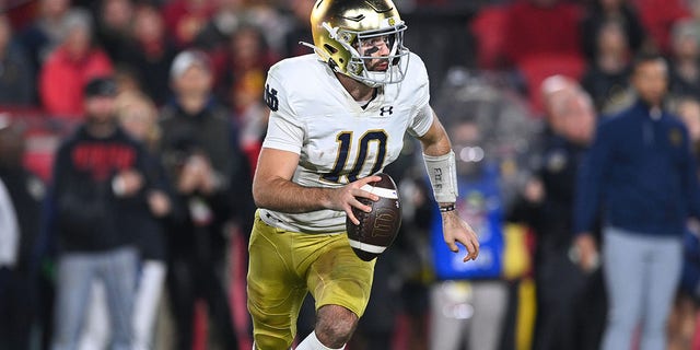 Notre Dame Fighting Irish quarterback Drew Pyne rolls out during the game against the USC Trojans at Los Angeles Memorial Coliseum in Los Angeles on Saturday.