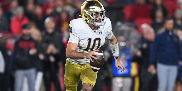 Notre Dame Fighting Irish quarterback Drew Pyne rolls out during the game against the USC Trojans at Los Angeles Memorial Coliseum in Los Angeles on Saturday.