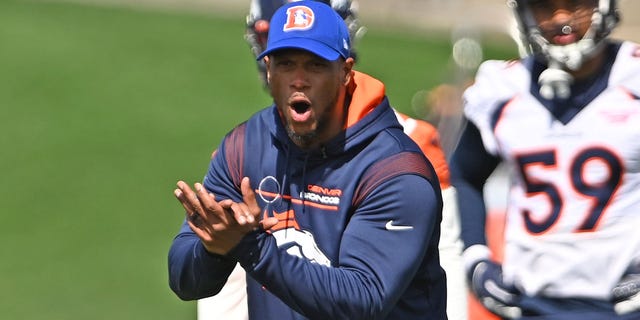 El Coordinador de Equipos Especiales, Dwayne Stukes, realiza simulacros con el jugador durante la práctica en el Centro de Capacitación de UCHealth el 27 de abril de 2022, en Centennial, Colorado.  Era el día 3 del minicampamento de los Denver Broncos.