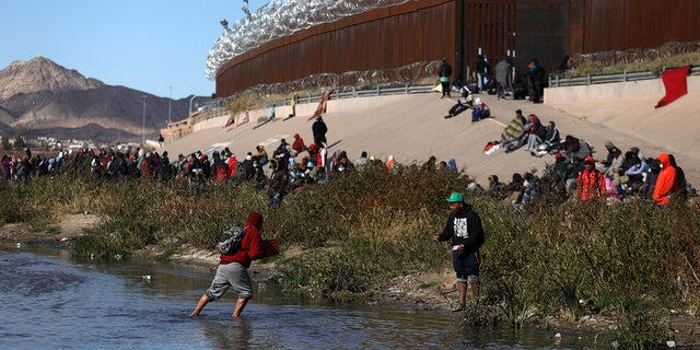 Migrants walk across the Rio Grande to surrender to US Border Patrol agents in El Paso, Texas, Dec. 13, 2022.
