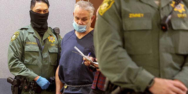 Eric Holland, who has an extensive criminal history, killed and dismembered his friend Richard Miller. Pictured: Eric Holland stands in court at the Regional Justice Center in Las Vegas, Nevada, on Dec. 28, 2021.