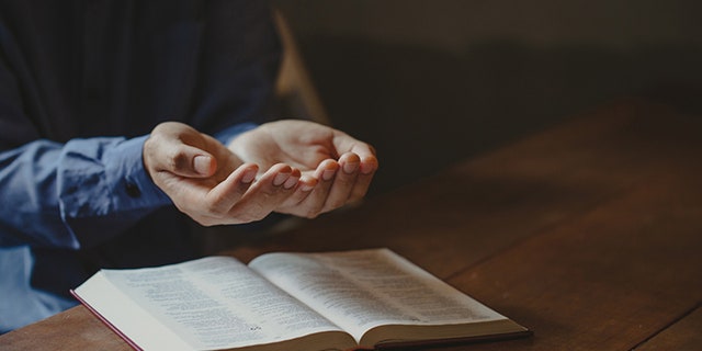 hands over Bible