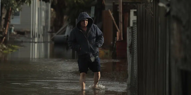 Salvador Sanchez, a resident of Seattle's South Park neighborhood for 30 years, walks in floodwaters next to his home Tuesday morning, Dec. 27, 2022.