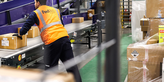 FedEx hub staff sort parcels.