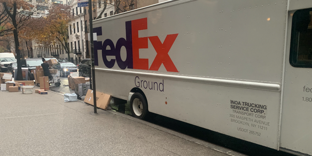 A FedEx delivery truck with packages getting unloaded in New York City.