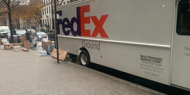 A FedEx delivery truck with packages getting unloaded in New York City.