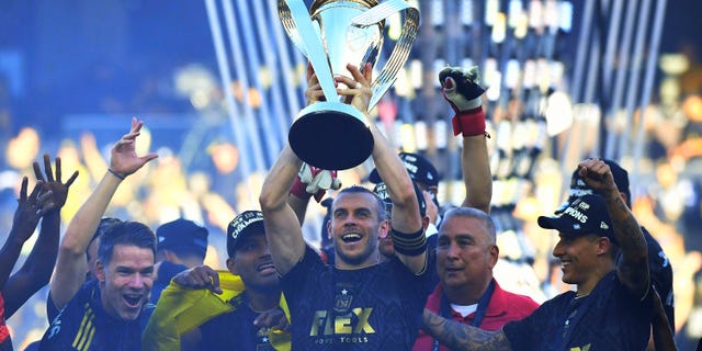 Gareth Bale of Los Angeles FC raises the championship trophy as he celebrates with teammates after the 2022 MLS Cup Final at Banc of California Stadium in Los Angeles on November 5, 2022.