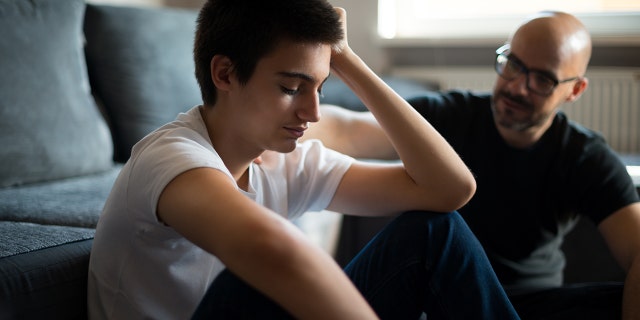 Upset young man talks with his father. More than anything, said one expert, it’s important to give the person nonjudgmental space to speak freely.