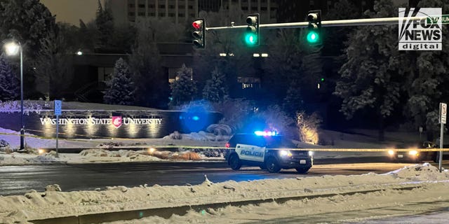 A patrol car is parked in the middle of the road near Washington State University on Dec. 15, 2022.
