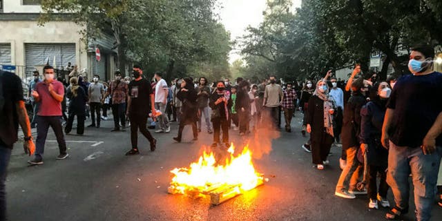 A fire burns on the streets of Iran as protesters continue to chant