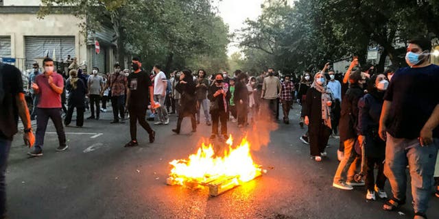 A fire burns on the streets of Iran as protesters continue to chant.