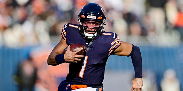 Chicago Bears number 1 Justin Fields runs the ball during the first half of a game against the Philadelphia Eagles at Soldier Field on December 18, 2022 in Chicago, Illinois.