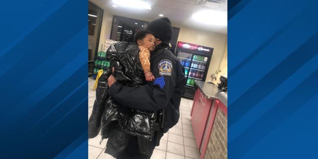 IMPD Sgt. Shawn Anderson holding missing baby Kason Thomas after the five-month old was found in an area pizzeria.