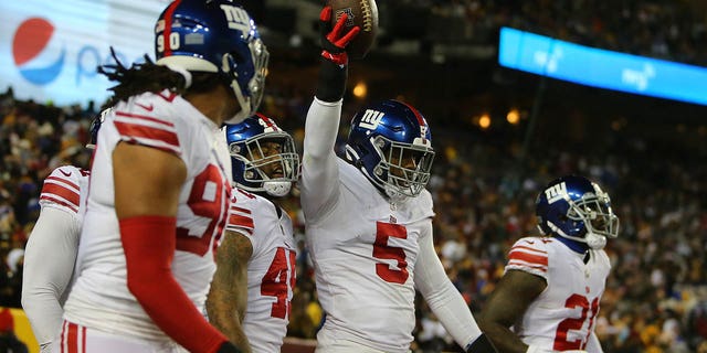 New York Giants linebacker Kayvon Thibodeaux (5) teammates celebrate with him after he scooped up a fumble and returned it for a touchdown during the New York Giants game versus the Washington Commanders on December 18, 2022, at FedEx Field in Landover, MD.