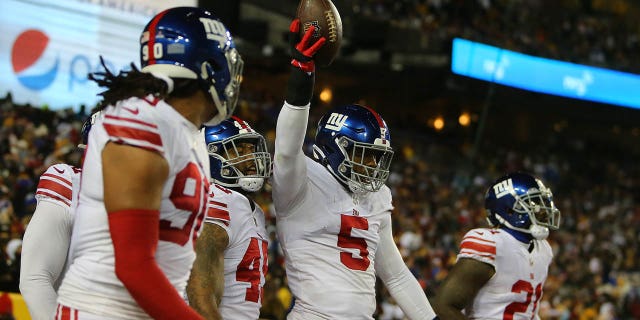 New York Giants linebacker Kayvon Thibodeaux (5) teammates celebrate with him after he scooped up a fumble and returned it for a touchdown during the New York Giants game versus the Washington Commanders on December 18, 2022, at FedEx Field in Landover, MD.