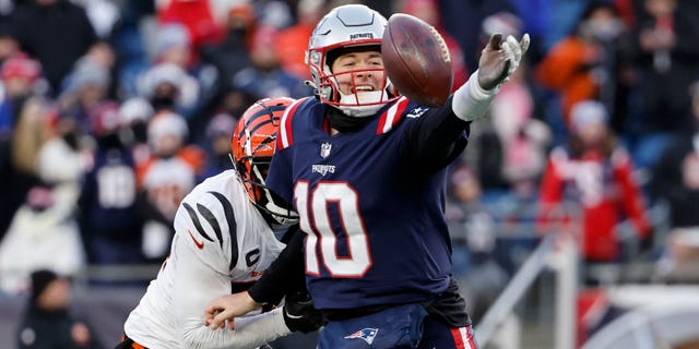 Von Bell, do Cincinnati Bengals, pressiona Mack Jones, do New England Patriots, enquanto ele tenta passar a bola em 24 de dezembro de 2022 em Foxboro.