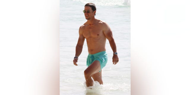 Mark Wahlberg vestiu sunga turquesa para um passeio na praia em Barbados. 
