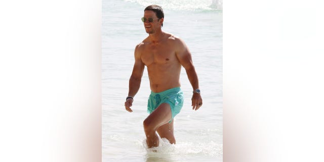 Mark Wahlberg donned turquoise swim trunks for a stroll on the beach in Barbados. 