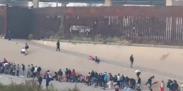 A massive line of migrants waiting to cross into the US