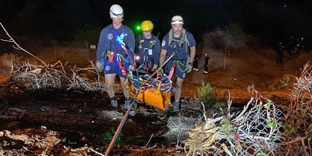 Crew members from the Phoenix Fire Department rappel down two 100-foot cliffs to tend to a suspect from a police pursuit.