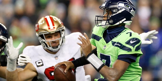 Nick Bosa #97 of the San Francisco 49ers pressures Geno Smith #7 of the Seattle Seahawks during the fourth quarter of the game at Lumen Field on December 15, 2022 in Seattle, Washington.