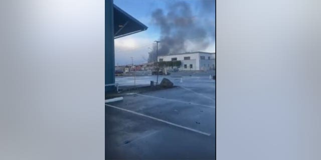 Smoke billows into the air in Oakland, CA after several big rig trucks caught on fire.