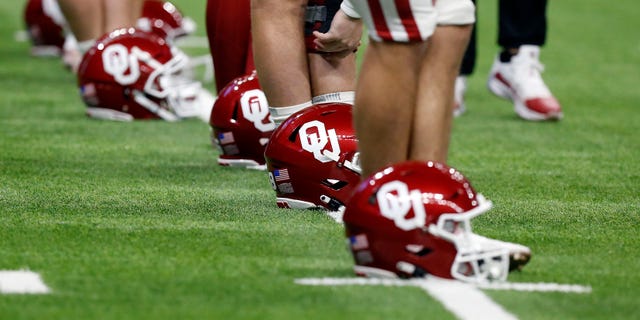 Oklahoma Sooners players line up their helmets while stretching prior to the game against the Oregon Ducks during the Valero Alamo Bowl football game at the Alamodome on December 29, 2021, in San Antonio, TX.