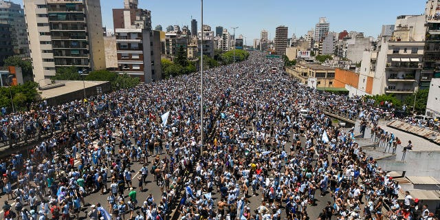 Argentinians crowd a highway for a homecoming parade for the nation’s soccer team that won the World Cup tournament in Buenos Aires on Dec. 20, 2022.