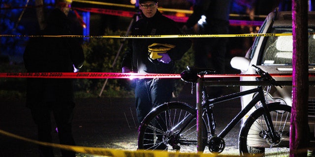 A police officer views where one person was shot dead and several others were wounded Feb. 19, 2022, in Portland, Ore.