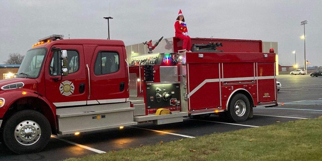 Hoeing can be seen dressed as an elf while sitting atop a firetruck in the school parking lot.