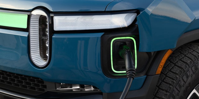 The R1S's charging port is located at the driver's-side front corner.
