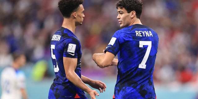 Giovanni Reyna of the U.S. interacts with teammate Antonee Robinson during a FIFA World Cup Qatar 2022 Group B match against England at Al Bayt Stadium Nov. 25, 2022, in Al Khor, Qatar.