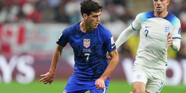 Gio Reyna of the United States, left, turns with the ball during a FIFA World Cup Qatar 2022 Group B match against England at Al Bayt Stadium Nov. 25, 2022, in Al Khor, Qatar.