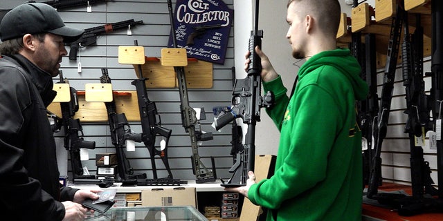 A customer looks at a rifle at Northwest Armory Tuesday, Dec. 6, 2022, in Milwaukie, Oregon.
