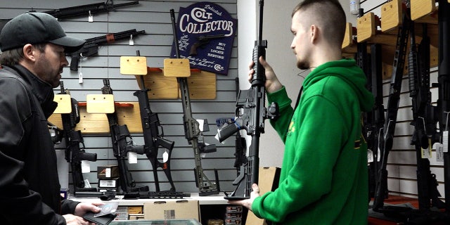 A customer looks at a rifle at Northwest Armory Tuesday, Dec. 6, 2022, in Milwaukie, Oregon.