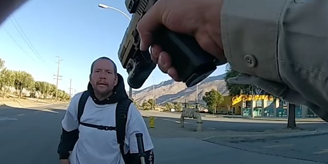 A Riverside County Sheriff's deputy points gun at suspect.