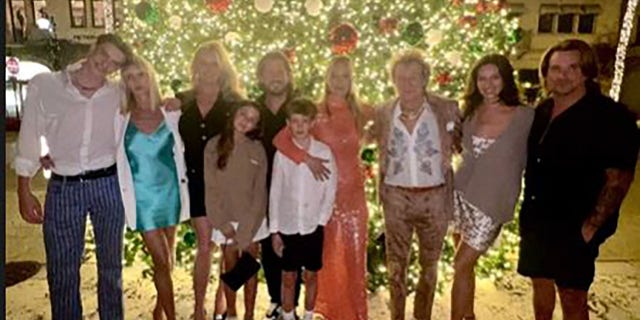 Rod Stewart with his wife and kids in front of a Christmas tree