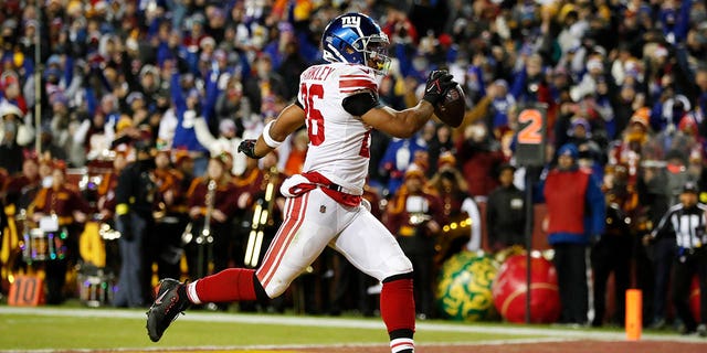Saquon Barkley #26 of the New York Giants scores a touchdown during the second quarter against the Washington Commanders at FedExField on December 18, 2022 in Landover, Maryland