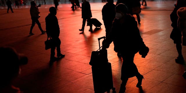 Chinese citizens in face masks outside Shanghai's rail station. China has begun rolling back COVID measures that have drawn the ire of both its citizens and the international community