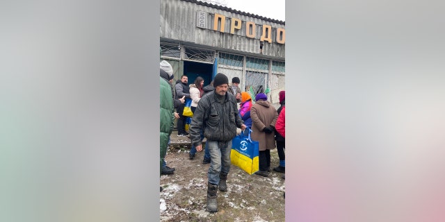 A man in Ukraine carries a bag of food distributed by Samaritan's Purse.