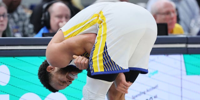 Stephen Curry of the Golden State Warriors grimaces after being hurt in the third quarter of a game against the Indiana Pacers at Gainbridge Fieldhouse Dec. 14, 2022, in Indianapolis.